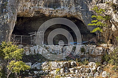 Panorama with high vertical limestone rocks and niches, ruins of former rock monastery Stock Photo